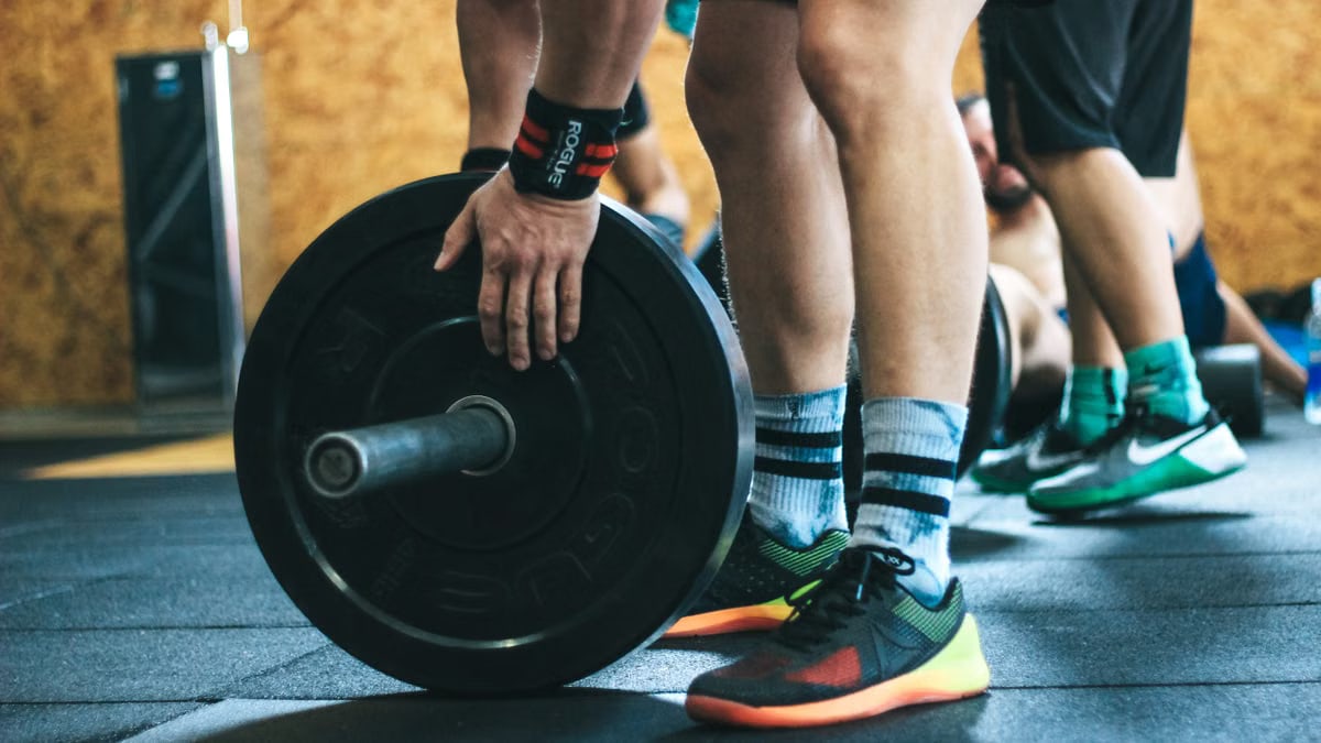 Close-up of a person lifting a barbell during a workout at a gym.